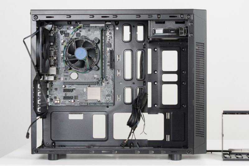 Building of PC, ATX motherboard inserted to black computer midi tower case.