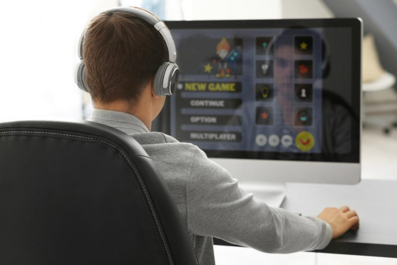 Teenager playing computer game at home