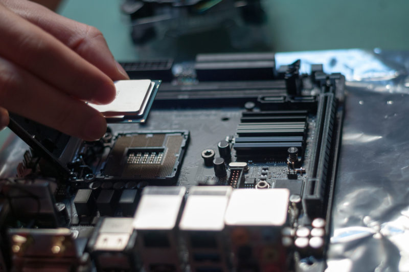 Assembling high performance personal computer, inserting CPU, processor into the motherboard socket, shallow depth of field