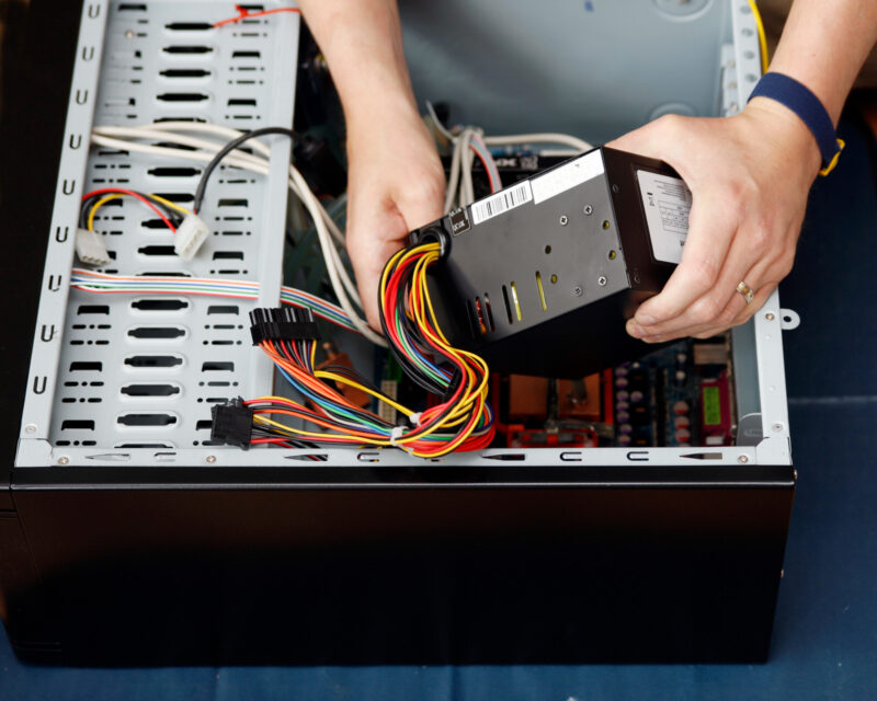 Engineer fits a PC Power Supply Unit