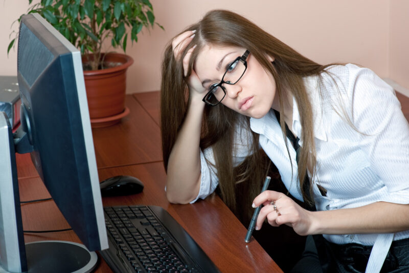 Young frustrated woman looking at the computer